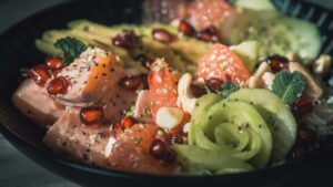 Bowl With Salmon, Cucumber, Pomegranate Seeds, And Other Fruits And Vegetables