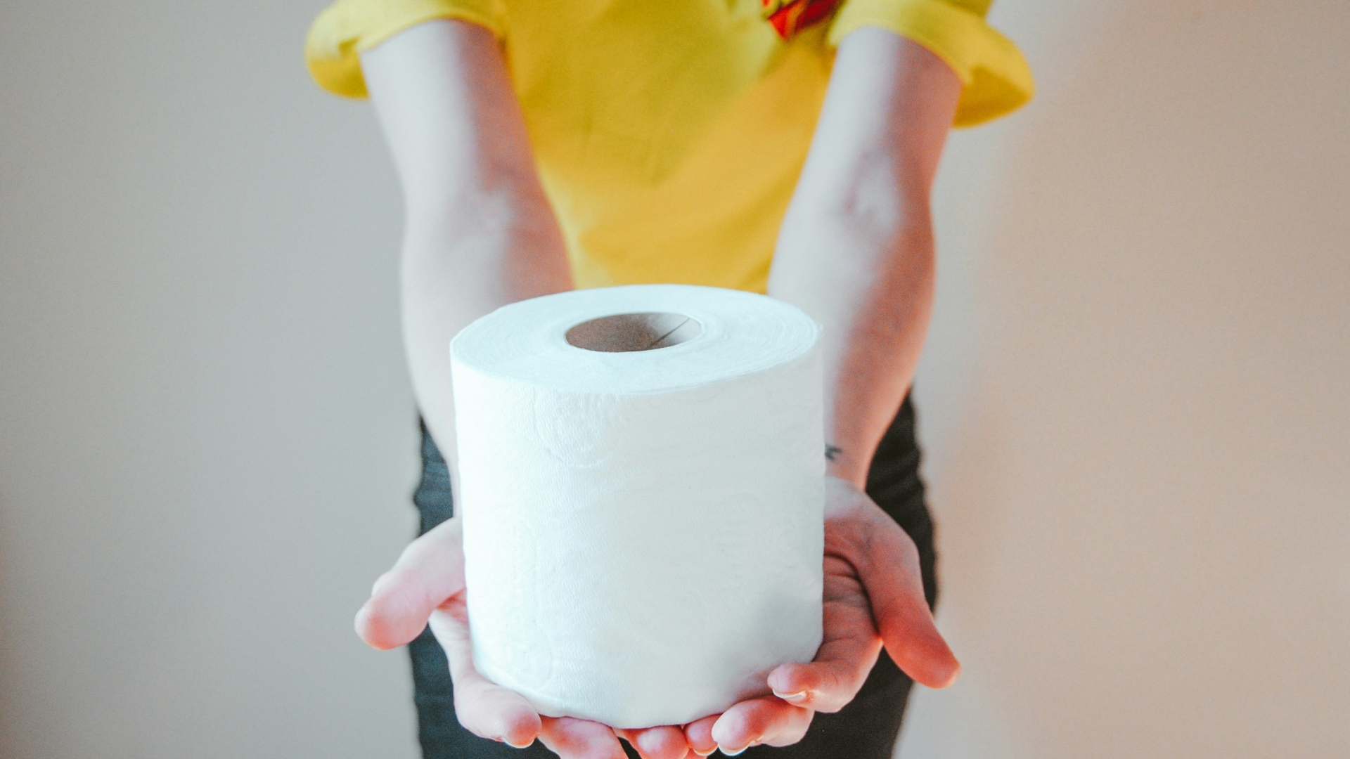 Person Holding Out Roll Of Toilet Paper