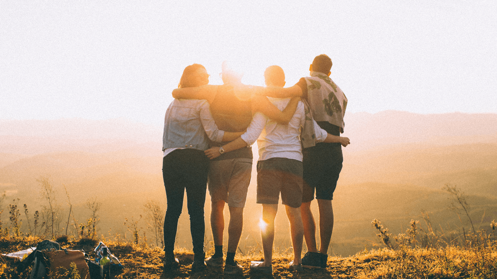 4 People With Arms Around Each Other Outside