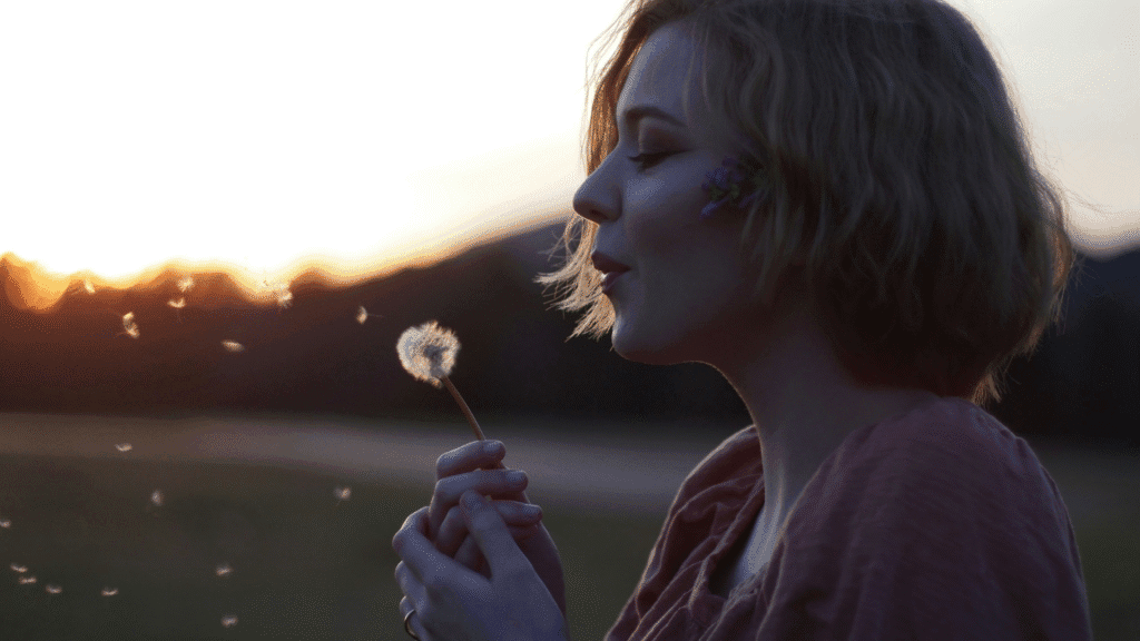 Woman Making Wish On Dandelion