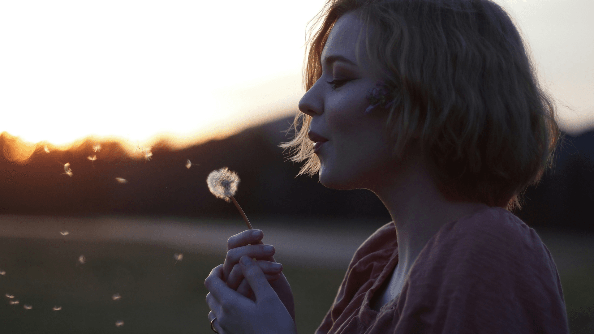 Woman Making Wish On Dandelion