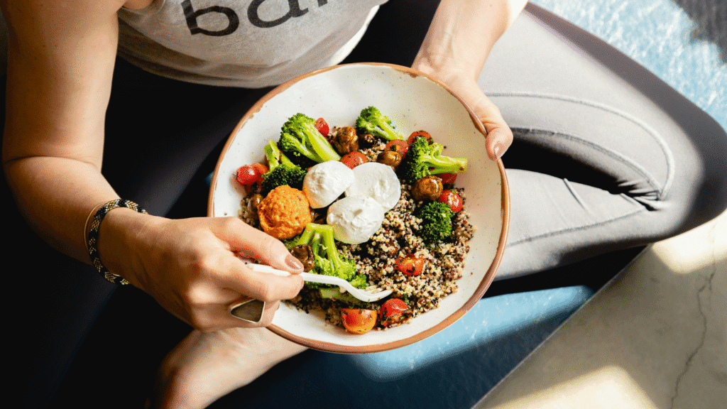Woman Sitting Cross-Legged With Bowl Of Healthy Food