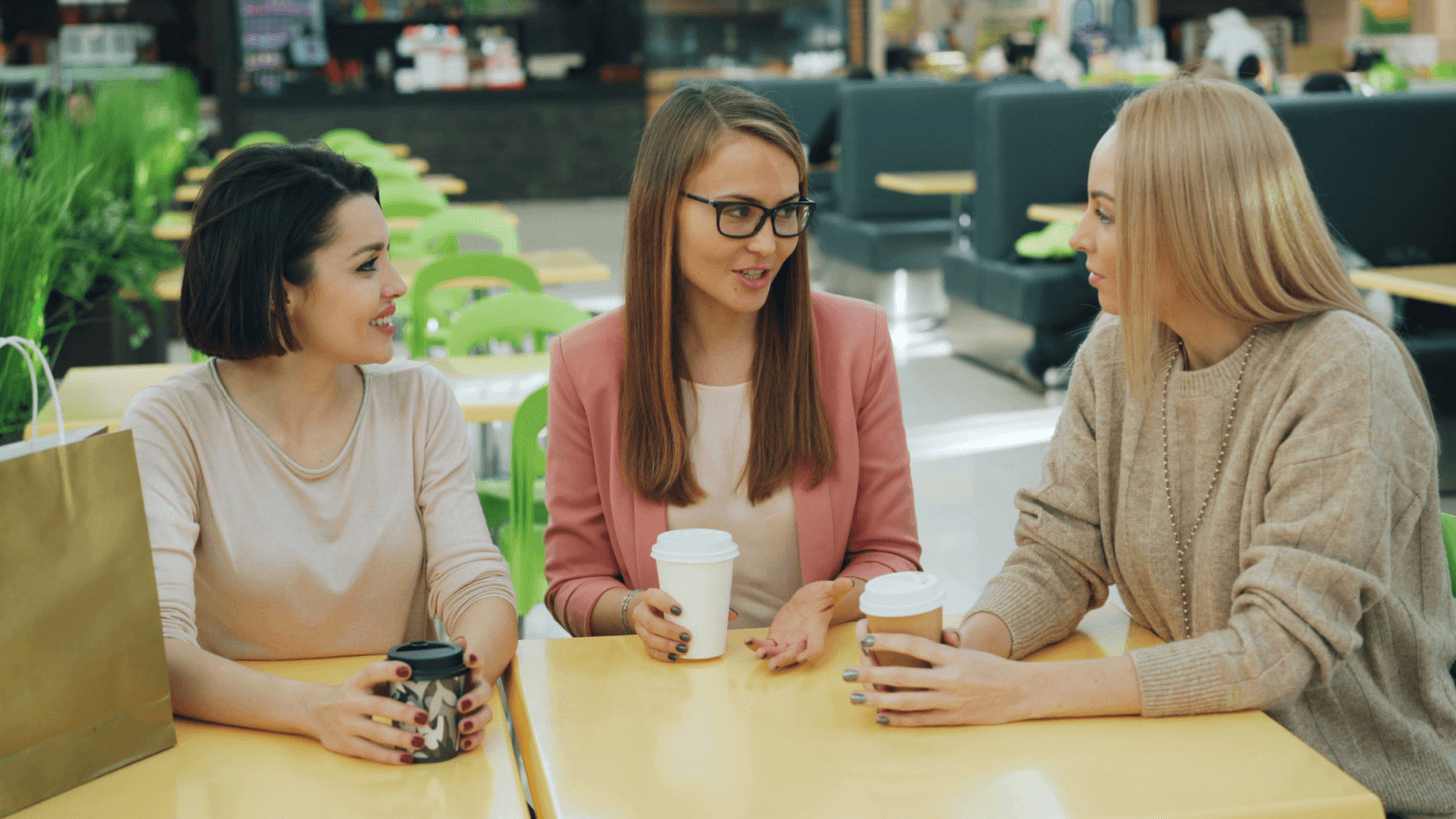 Three Women Sitting Around A Table Talking