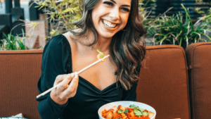 Woman Laughing And Eating At Restaurant