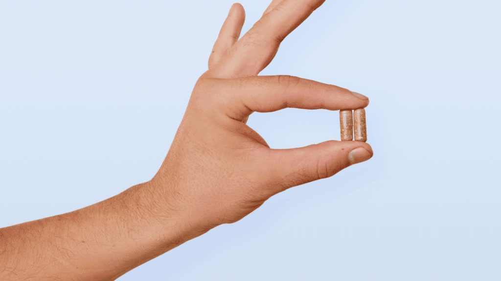 Two capsules in a person's hand