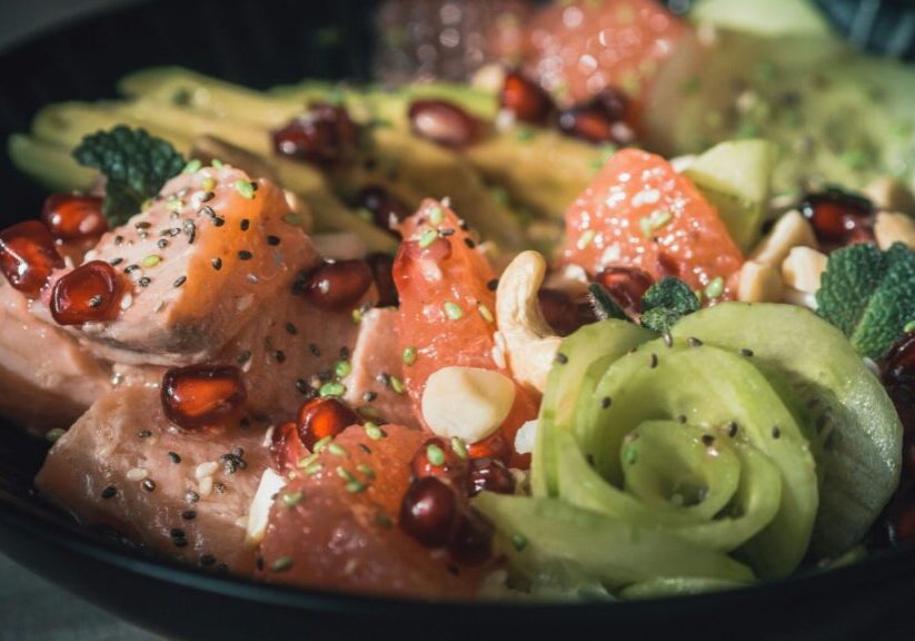 Bowl With Salmon, Cucumber, Pomegranate Seeds, And Other Fruits And Vegetables