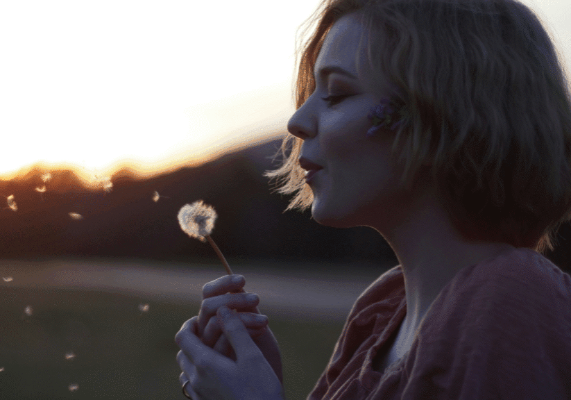 Woman Making Wish On Dandelion