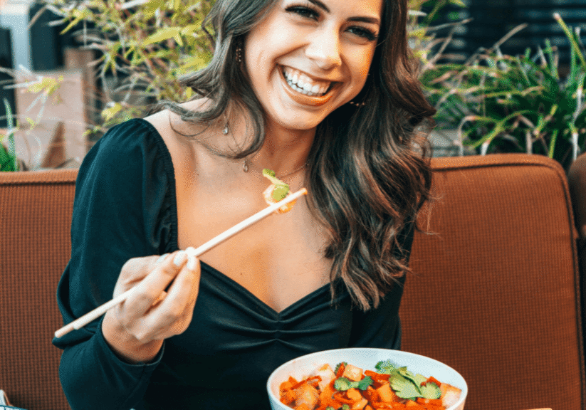 Woman Laughing And Eating At Restaurant