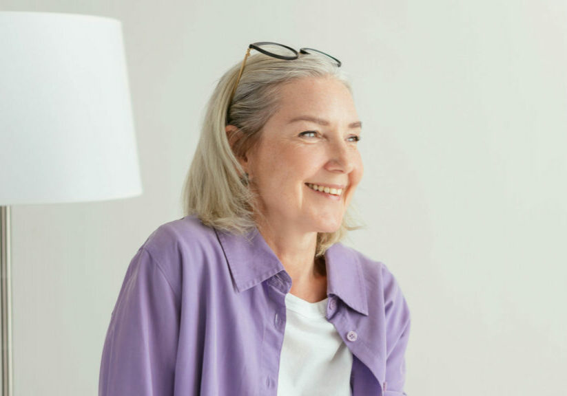 Elderly Woman Sitting In A Purple Shirt Smiling