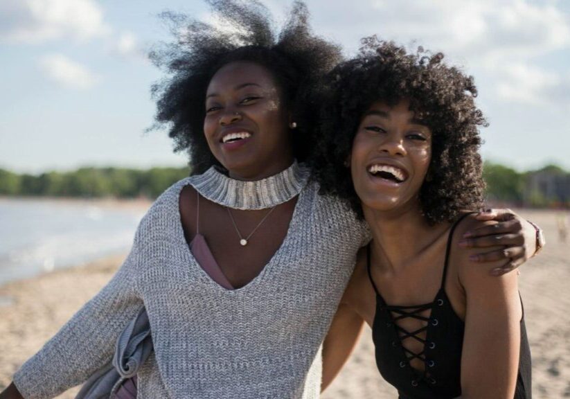 Two Women On The Beach Laughing